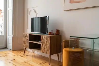 a tv on a wooden stand in a living room at Sky de Loios in Porto