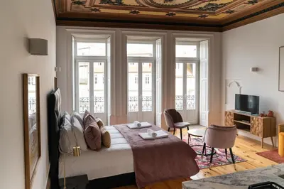 a bedroom with a bed and a room with windows at Sky de Loios in Porto