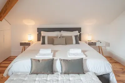 a bedroom with a large white bed with pillows at Tomas Loft in Porto