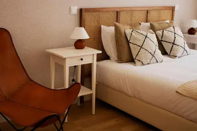 a bedroom with a bed and a table and a chair at Casa do Paraiso - City Center Gem (w/ AC) by LovelyStay in Porto