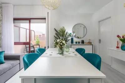 a living room with a white table and blue chairs at Apartamento Paradise Porto in Porto