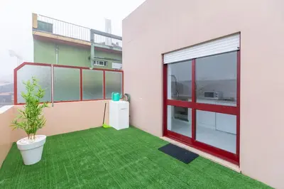 a balcony with a green floor and a plant at Apartamento Paradise Porto in Porto