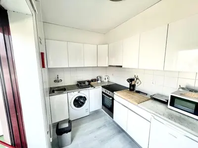 a kitchen with white cabinets and a washing machine at Apartamento Paradise Porto in Porto