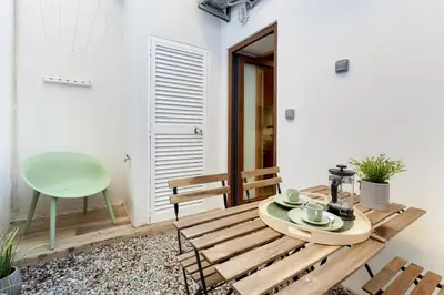 a patio with a wooden table and a green chair at D&S - Alegria 630 in Porto