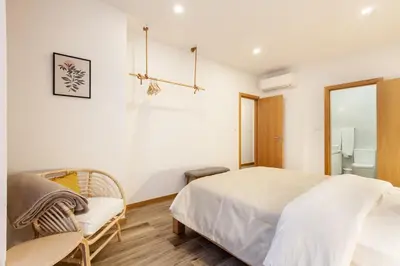 a bedroom with a bed and a chair and a mirror at D&S - Alegria 630 in Porto