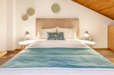 a bedroom with a large bed with two lamps at D&S - Alegria 630 in Porto