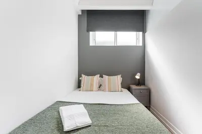 a bedroom with a bed with a white mattress and a window at GuestReady - Gold Leaf in Porto