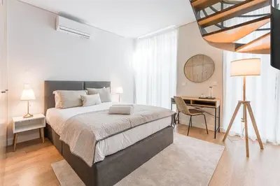 a bedroom with a large bed and a desk at GuestReady - Porto by the Bridge in Vila Nova de Gaia