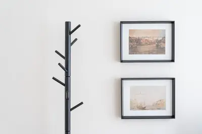 a set of three framed pictures on a wall with a pole at GuestReady - Porto by the Bridge in Vila Nova de Gaia