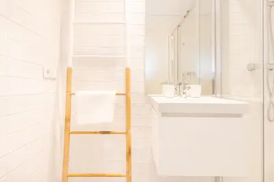 a white bathroom with a sink and a mirror at 12 Sweet Caroline in Porto