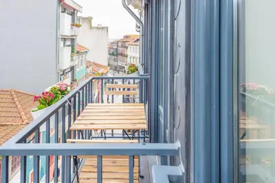a wooden bench on the balcony of a building at 12 Sweet Caroline in Porto
