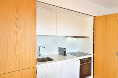 a kitchen with white cabinets and a sink at Sé do Porto - Loft with City View in Porto