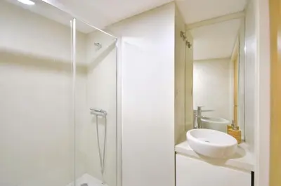 a white bathroom with a sink and a shower at Sé do Porto - Loft with City View in Porto