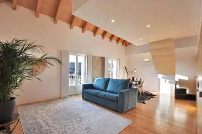a living room with a blue couch and a table at Sé do Porto - Loft with City View in Porto