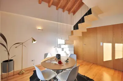 a dining room with a round table and white chairs at Sé do Porto - Loft with City View in Porto
