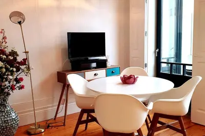 a dining room with a white table and chairs at OHH - General da Silveira Flat Deluxe Apartment - Downtown in Porto