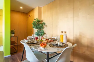 a dining room with a table with food on it at Host Wise - Restful Minimalist Flat - Balcony in Porto
