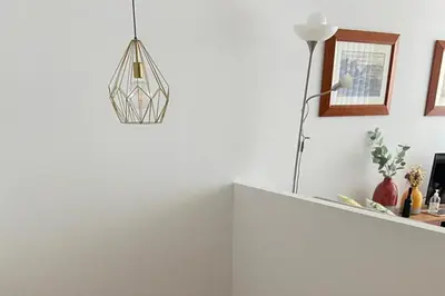 a room with a white wall with a light fixture at Duplex Apt - Sleeps 4 - Roof Terrace - Balcony in Porto