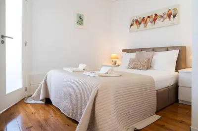 a bedroom with a bed with a white comforter at Belleville in Porto