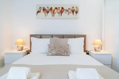 a white bedroom with a bed with two night stands at Belleville in Porto