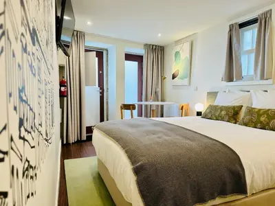a bedroom with a large bed and a table at CHARM APARTMENTS PORTO - Centro Batalha 2 in Porto