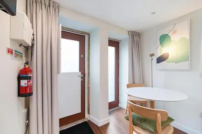 a room with a table and chairs and a door at CHARM APARTMENTS PORTO - Centro Batalha 2 in Porto