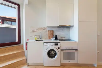 a kitchen with a washing machine and a washer at Central Superb Flat w/ AC & Balcony by LovelyStay in Porto