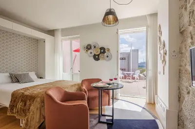 a bedroom with a bed and a couch and a table at The Downtown Charming Apartments in Porto