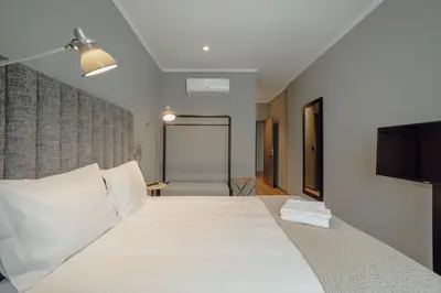 a bedroom with a large white bed and a television at River Eyes Suites in Vila Nova de Gaia