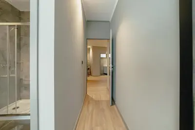 a hallway with white walls and a glass door at River Eyes Suites in Vila Nova de Gaia
