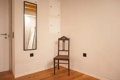 a mirror and a wooden stool in a room at Loungy Porto in Porto