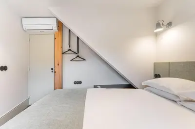 a bedroom with a bed and a staircase at GuestReady - Mercadores 150 in Porto