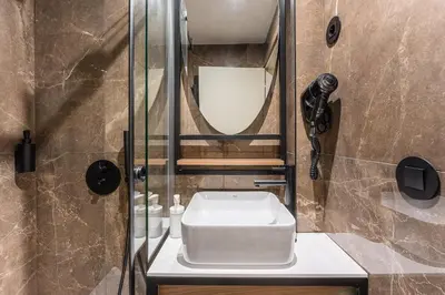 a bathroom with a toilet and a shower and a phone at GuestReady - Mercadores 150 in Porto