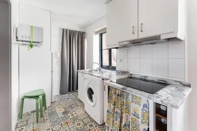 a white kitchen with a washing machine in it at GuestReady - Modern Comfort in Downtown in Porto
