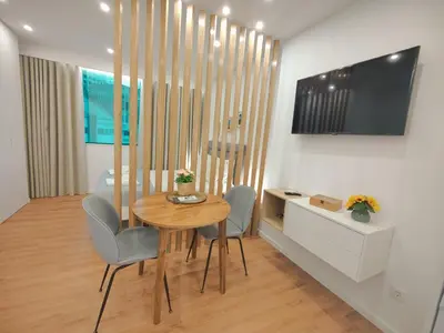 a dining room with a table and chairs and a television at A Window to Porto – Premium Apartment Porto Downtown in Porto