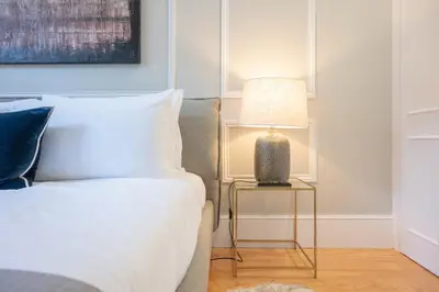 a bedroom with a bed and a table with a lamp at Cocoon Almada in Porto