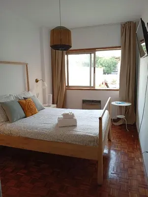 a bedroom with a large bed with a window at Travel & Live Bragas in Porto