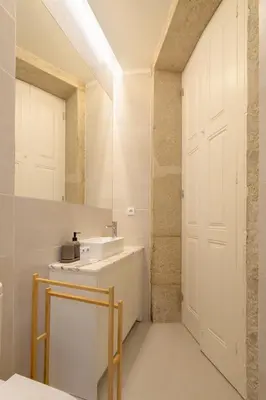a bathroom with a sink and a white door at Host Wise - Enchanting Design Flat - Premium Location in Porto