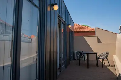 a patio with two chairs and a table on a balcony at Spacious Studio w/ Balcony & AC by LovelyStay in Porto