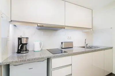 a kitchen with white cabinets and a counter top at CHARM APARTMENTS PORTO - Centro Batalha 1 in Porto