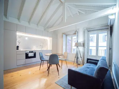 a living room with a blue couch and a table at OportoCityView - Trindade Almada in Porto