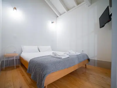 a bedroom with a bed with a tv on the wall at OportoCityView - Trindade Almada in Porto