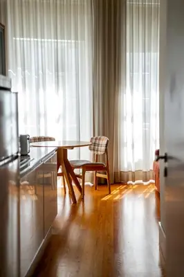 a kitchen with a table and a chair in front of a window at Mouzinho 129 - Sobreiro in Porto