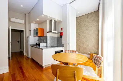 a kitchen with a wooden table and chairs in a room at Mouzinho 129 - Sobreiro in Porto