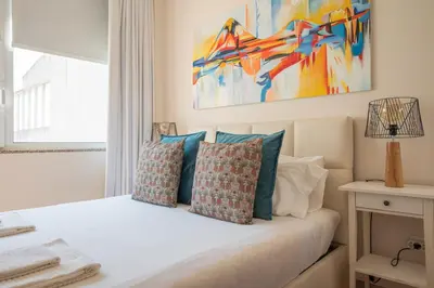 a bedroom with a white bed with blue pillows at PortoTile By RDC in Porto