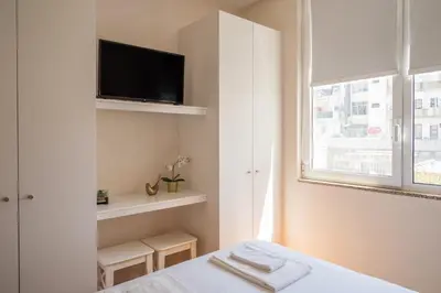 a bedroom with a bed and a tv on a wall at PortoTile By RDC in Porto
