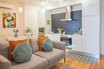 a living room with a couch and a kitchen at PortoTile By RDC in Porto