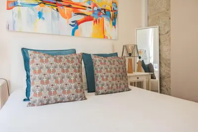 a white bed with pillows and a painting on the wall at PortoTile By RDC in Porto