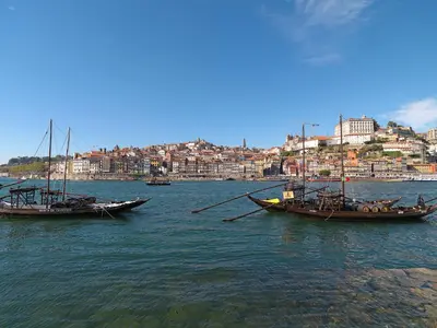 two boats sitting in the water near a city at FLH Gaia Wine Cellars Flat in Vila Nova de Gaia