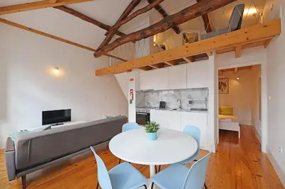 a living room with a white table and chairs at FLH Porto Santa Catarina Duplex in Porto